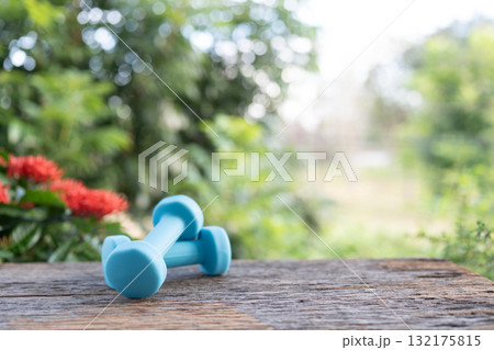 Blue dumbbells on wooden table Blue dumbbells on wooden table 132175815