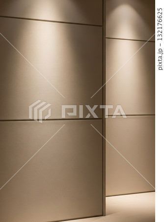 Textured Beige Wall Panels Illuminated by Warm Spotlights in Building 132176625