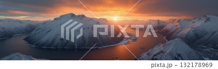 A beautiful northern landscape at sunset, with snow-covered mountains and a lake. 132178969
