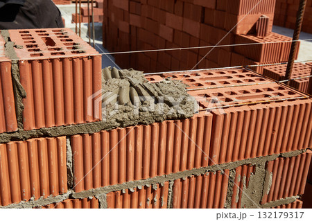 Brickwork construction in progress at a building site during daylight hours 132179317