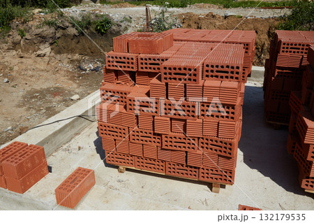 Bricks stacked neatly at a construction site in daylight preparing for building construction activity Bricks stacked neatly at a construction site in daylight preparing for building construction activity 132179535