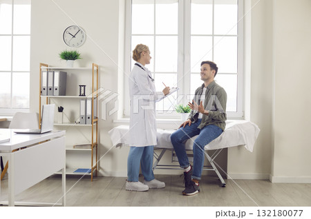 Doctor, caring female nurse talking to consult patient in modern private clinic or hospital 132180077