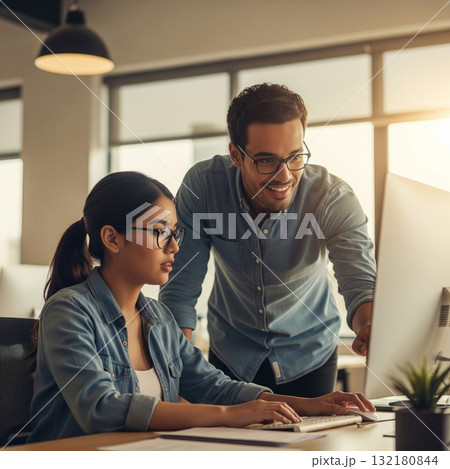 Two People Collaborate at a Computer in a Modern Office Setting 132180844