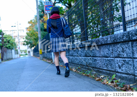 寒い日に部活で暗い道を登下校する女子高生　高校生の冬服　後ろ姿　登校下校 132182804