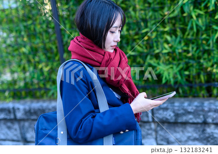 寒い日スマホを使いながら登下校する女子高生 冬服で通学する高校生 ブレザー 登校下校 寒い日スマホを使いながら登下校する女子高生 冬服で通学する高校生 ブレザー 登校下校 132183241