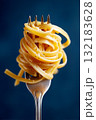 Close up of a fork holding a swirl of cooked pasta against a vibrant blue background 132183628