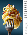 Hyperrealistic macro shot of fork holding spaghetti with bacon and herbs on blue background 132183631
