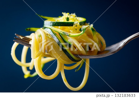 Hyperrealistic close-up of a fork holding spaghetti and zucchini strands with vibrant colors 132183633