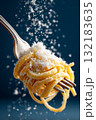 Hyperrealistic close-up of a fork holding spaghetti with grated cheese and falling snowflakes 132183635
