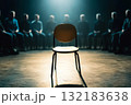 Empty chair positioned away from a circle of seated individuals, symbolizing isolation and exclusion 132183638