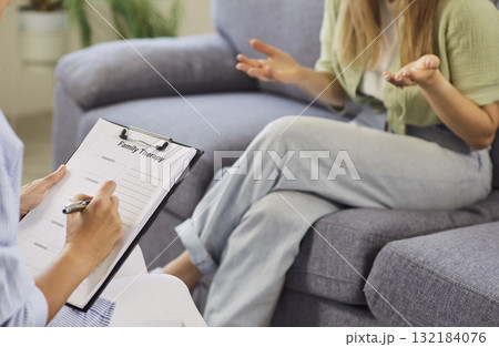 Therapist taking notes while patient gestures during supportive counseling session Therapist taking notes while patient gestures during supportive counseling session 132184076