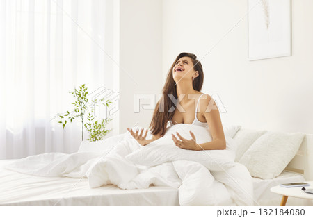 Portrait of angry stressed young woman sitting in bed in bedroom suffering from depression Portrait of angry stressed young woman sitting in bed in bedroom suffering from depression 132184080