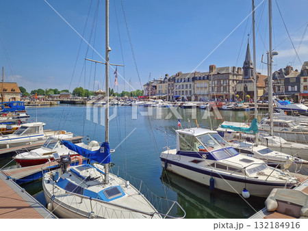 Honfleur, Normandy, France - May 30, 2025: Honfleur Vieux Bassin harbor with boats and yachts moored in the still water, and a row of colorful buildings in the background Honfleur, Normandy, France - May 30, 2025: Honfleur Vieux Bassin harbor with boats and yachts moored in the still water, and a row of colorful buildings in the background 132184916