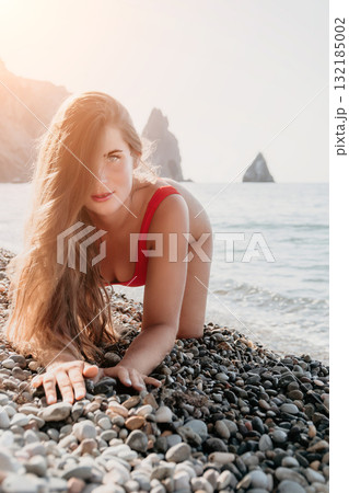 Woman in Red Swimsuit Posing on a Pebbly Beach Woman in Red Swimsuit Posing on a Pebbly Beach 132185002
