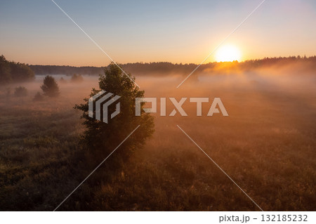 Bright photo of valley in fog and a rising sun. Morning landscape in the countryside 132185232