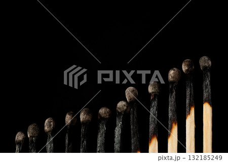 Rising line of burnt matches against black background. Concept of uprise movement, positive statistics, elevation 132185249