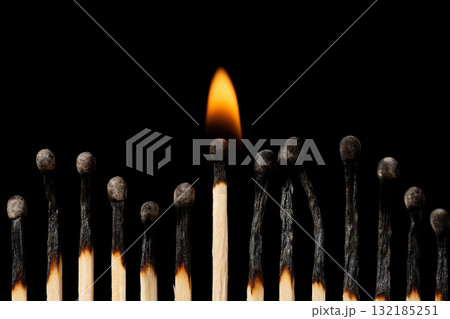 Group of burnt mathces with one still burning in the middle. Concept of firmness, power. 132185251