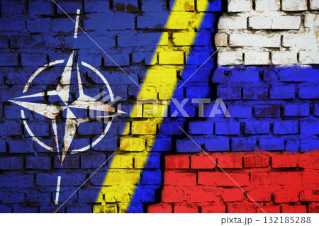 Kyiv, Ukraine - 12.09.2021: Relationships between NATO, Ukraine and Russia concept. Cracked wall with flags 132185288