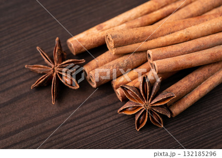 Close-up shot of cinnamon and some stars of anise against black wooden background. Cinnamon and star anise spices 132185296