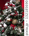Christmas tree adorned with ornaments and snow, creating a festive holiday atmosphere 132185690