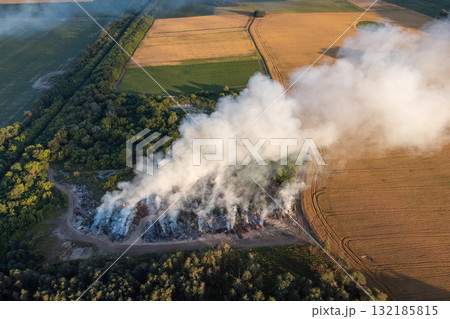 Drone photo of burning wastes at garbage site. Polluting air with dangerous toxic gases of burnt wastes Drone photo of burning wastes at garbage site. Polluting air with dangerous toxic gases of burnt wastes 132185815