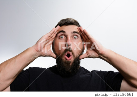 Surprised man with beard and open mouth against white background 132186661