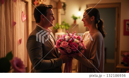 Smiling couple sharing a bouquet of roses in warm, cozy lighting, surrounded by heart decorations. Concept of love and romance 132186936