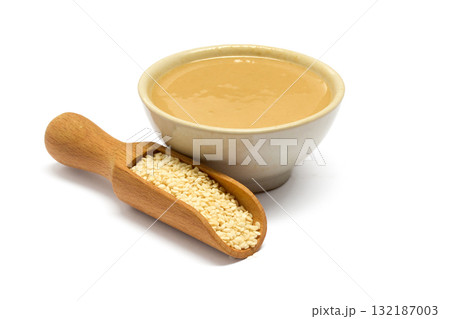 Sesame Seeds and Tahini. A ceramic bowl of creamy tahini and a scoop of sesame seeds 132187003
