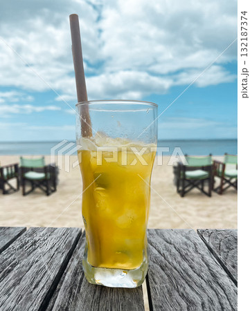 A glass of a drink with a straw in it. A glass of a drink with a straw in it. 132187374