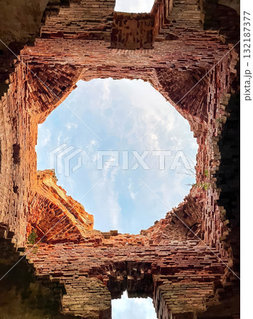 A brick building with a hole in the middle. 132187377