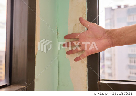 Conducting a Thorough Hand Inspection of Wall Damage in a Modern Apartment Space Conducting a Thorough Hand Inspection of Wall Damage in a Modern Apartment Space 132187512
