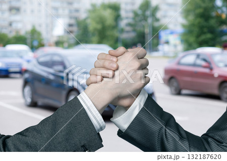 Handshake in the city while cars pass by in the background. 132187620
