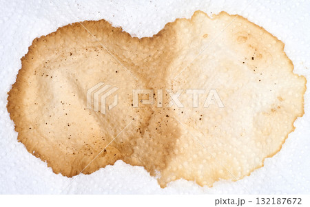 Macro shot of a large, dried coffee stain on a textured white paper napkin Macro shot of a large, dried coffee stain on a textured white paper napkin 132187672