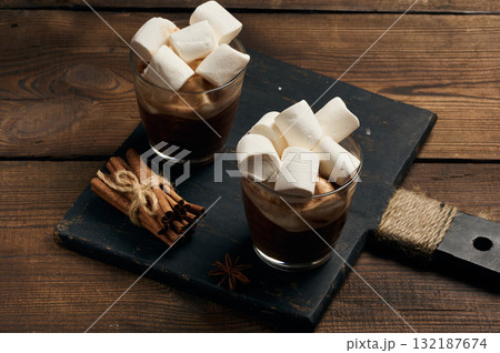 Glasses of hot chocolate with fluffy marshmallows on a wooden table. Glasses of hot chocolate with fluffy marshmallows on a wooden table. 132187674