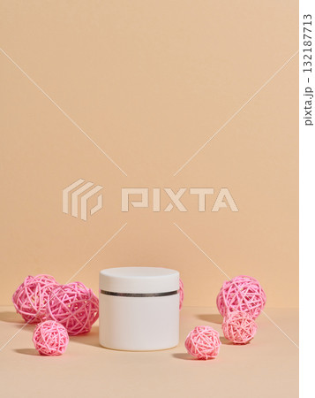 An unmarked white cosmetic jar among decorative pink rattan balls An unmarked white cosmetic jar among decorative pink rattan balls 132187713