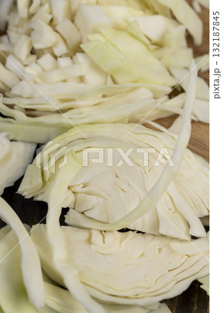 white cabbage during slicing for salad preparation, pieces of sliced white cabbage , details of fresh cabbage chopped into small pieces for convenience of cooking 132187845