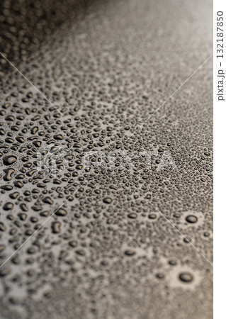 Black glass surface in water droplets, wet mirrored black glass in a large number of water drops, close up 132187850
