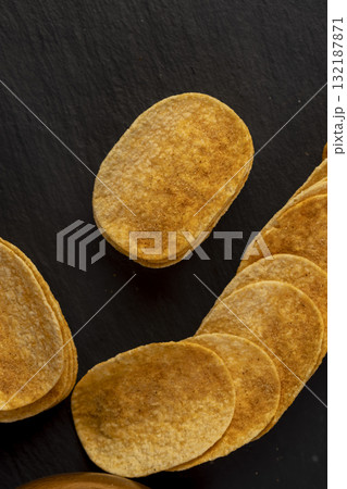 crispy chips fried in oil and sprinkled with spices of dried red sweet pepper, a large number of delicious salty sweet pepper-flavored chips with aromatic spices crispy chips fried in oil and sprinkled with spices of dried red sweet pepper, a large number of delicious salty sweet pepper-flavored chips with aromatic spices 132187871