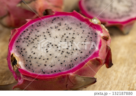 ripe red pitaya with lots of small black seeds and white soft sweet flesh inside, sweet ripe dragon fruit with black small seeds and light flesh cut in half ripe red pitaya with lots of small black seeds and white soft sweet flesh inside, sweet ripe dragon fruit with black small seeds and light flesh cut in half 132187880