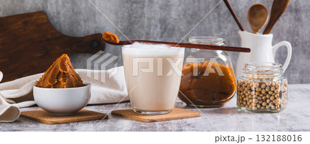 Miso-Spiked latte in a glass and a bowl of miso paste on the table web banner Miso-Spiked latte in a glass and a bowl of miso paste on the table web banner 132188016