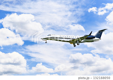 Private business plane flying under blue sky with white clouds 132188050