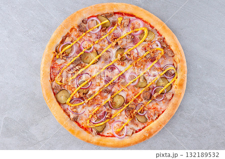 Cheeseburger Style Pizza with Pickles, Red Onion, Ground Beef, Crispy Onions and Mustard Drizzle on Gray Background 132189532