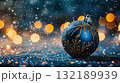 A blue and gold ball sits on a pile of gold and brown twigs. Christmas blue background. Copy place 132189939