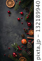 Christmas black background with a bunch of red and green decorations. The decorations include oranges, pomegranates, and cinnamon 132189940
