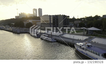 Passenger ships docked at a river embankment in the city at sunset. Clip Passenger ships docked at a river embankment in the city at sunset. Clip 132190328
