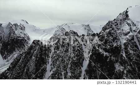 Majestic snow capped mountain peaks under a cloudy sky. Media 132190441