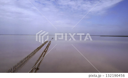 Drone flying backwards over a pink salt lake. Media Drone flying backwards over a pink salt lake. Media 132190456