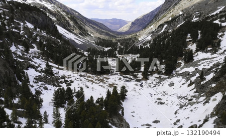 Snowy valley panning across mountain range with pine trees. Media 132190494