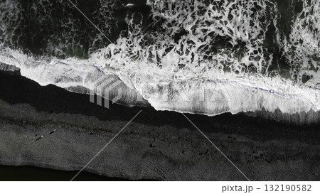 Waves crashing on black sand beach 132190582