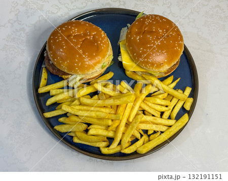 Two Cheeseburgers and French Fries on Blue Plate Two Cheeseburgers and French Fries on Blue Plate 132191151